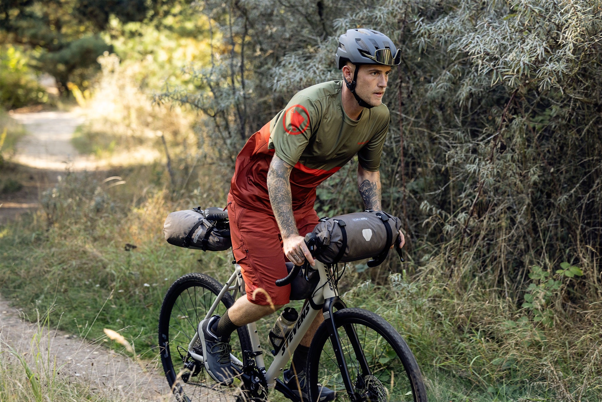 Fietser bevestigt ORTLIEB Handlebar-Pack Flex in dark-sand aan stuur tijdens offroadrit