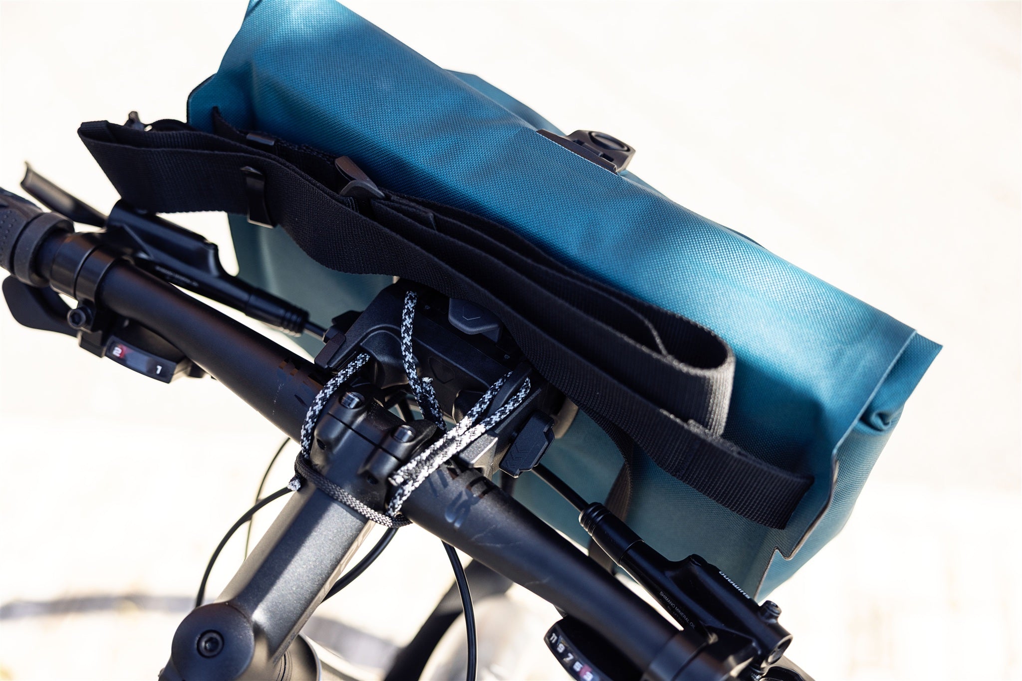 Close-up van de petrol ORTLIEB Velo-Sling Flex stuurtas met Bar-Lock-bevestiging van waterdicht materiaal op fiets.
