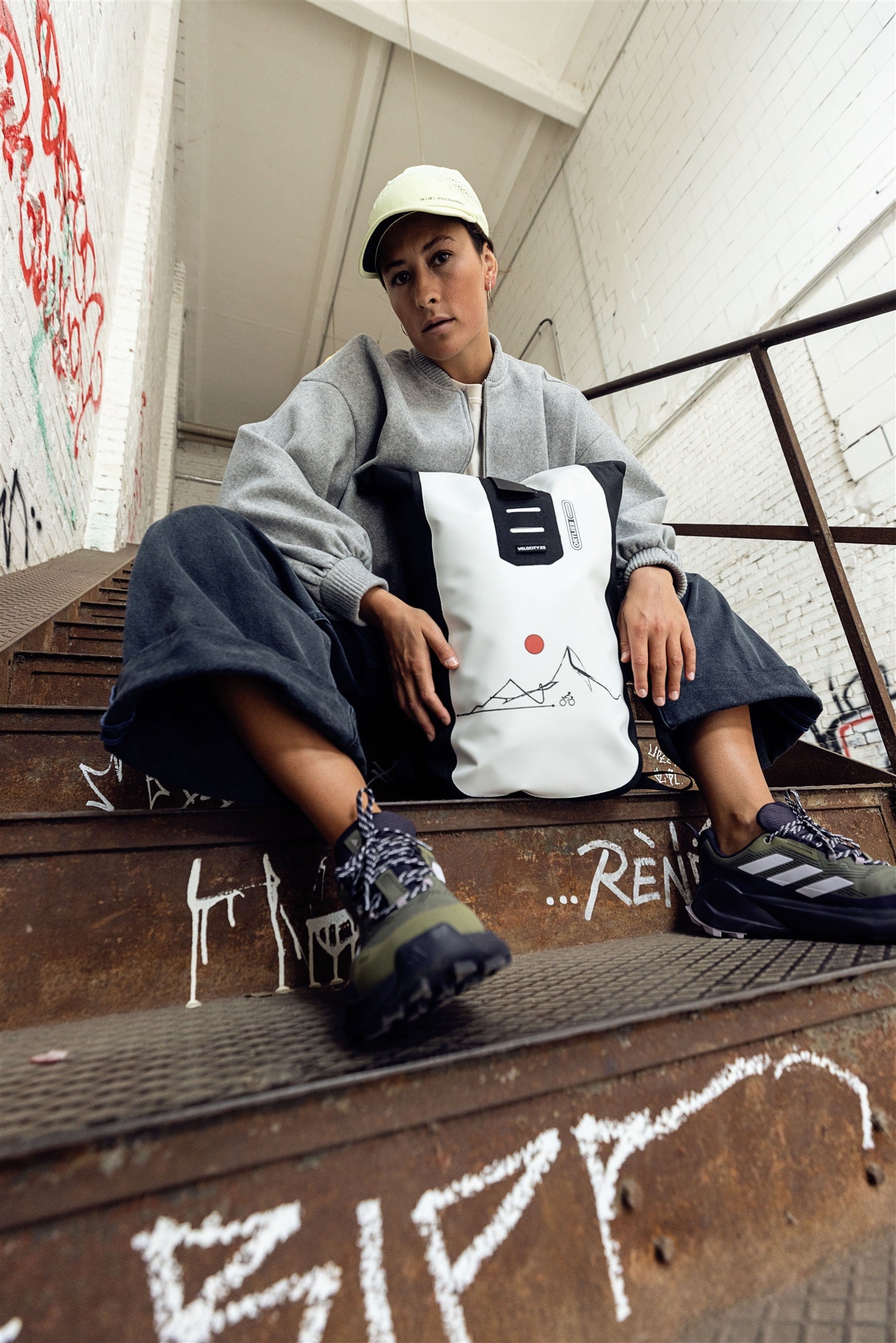 Persoon fietst in stedelijke omgeving met wit-zwarte ORTLIEB Velocity Design rugzak